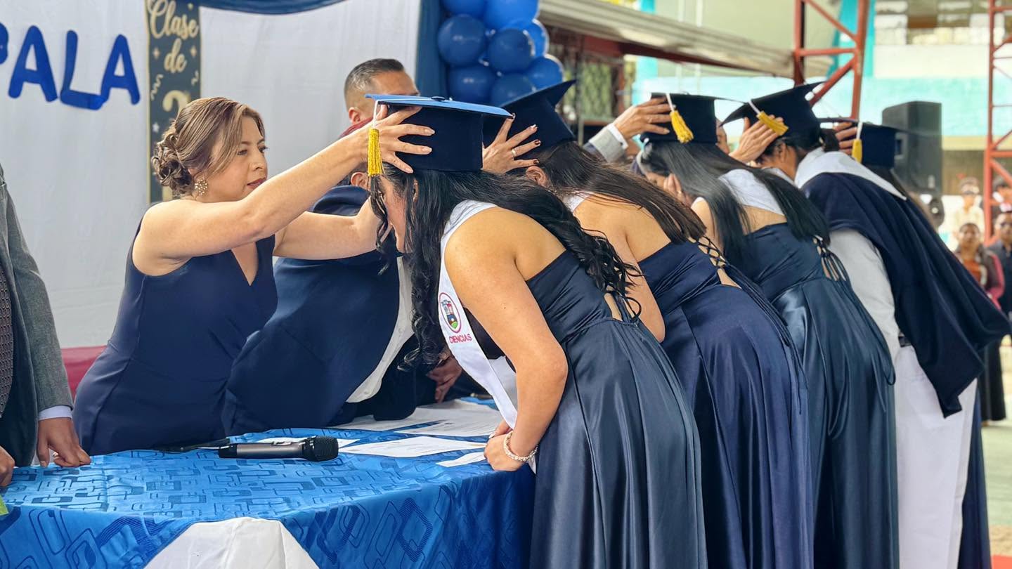 La alcaldesa subrogante Carmita Pesántez colocando el birrete a un estudiante durante la ceremonia