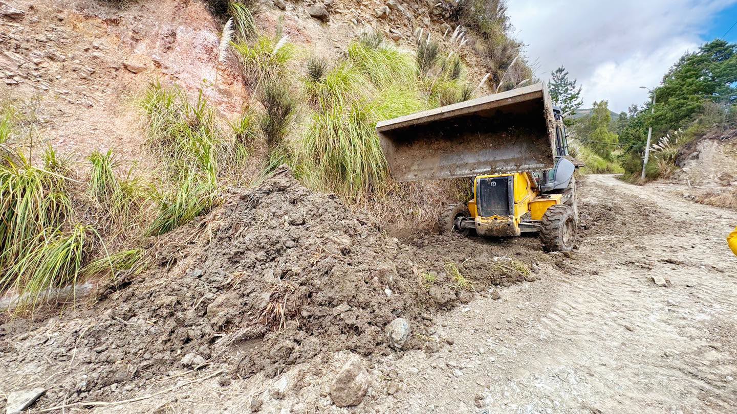 Retroexcavadora realizando trabajos de mantenimiento vial en Guachapala
