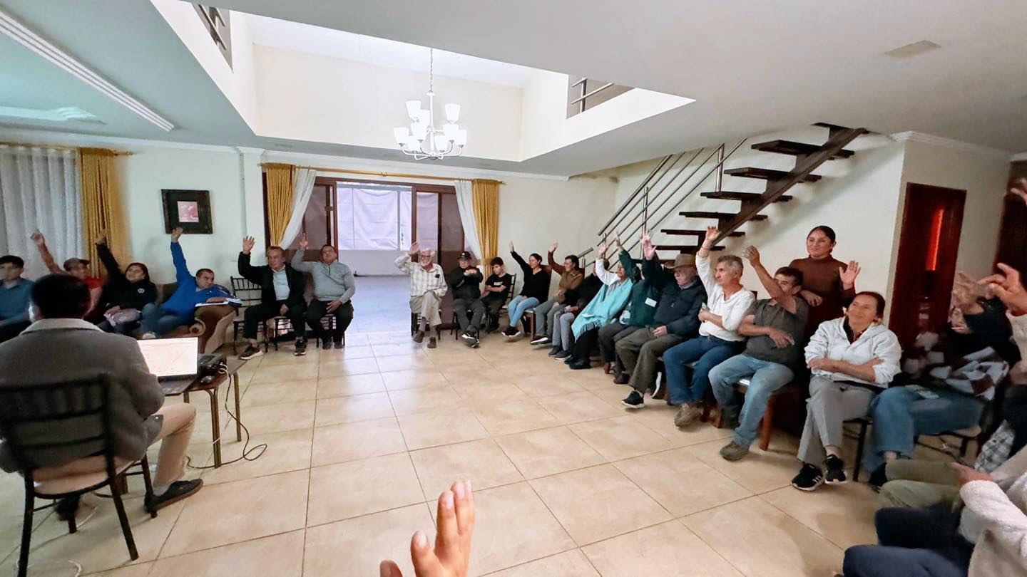 Moradores de Monjas levantando la mano durante la socialización del proyecto de la nueva Casa Comunal
