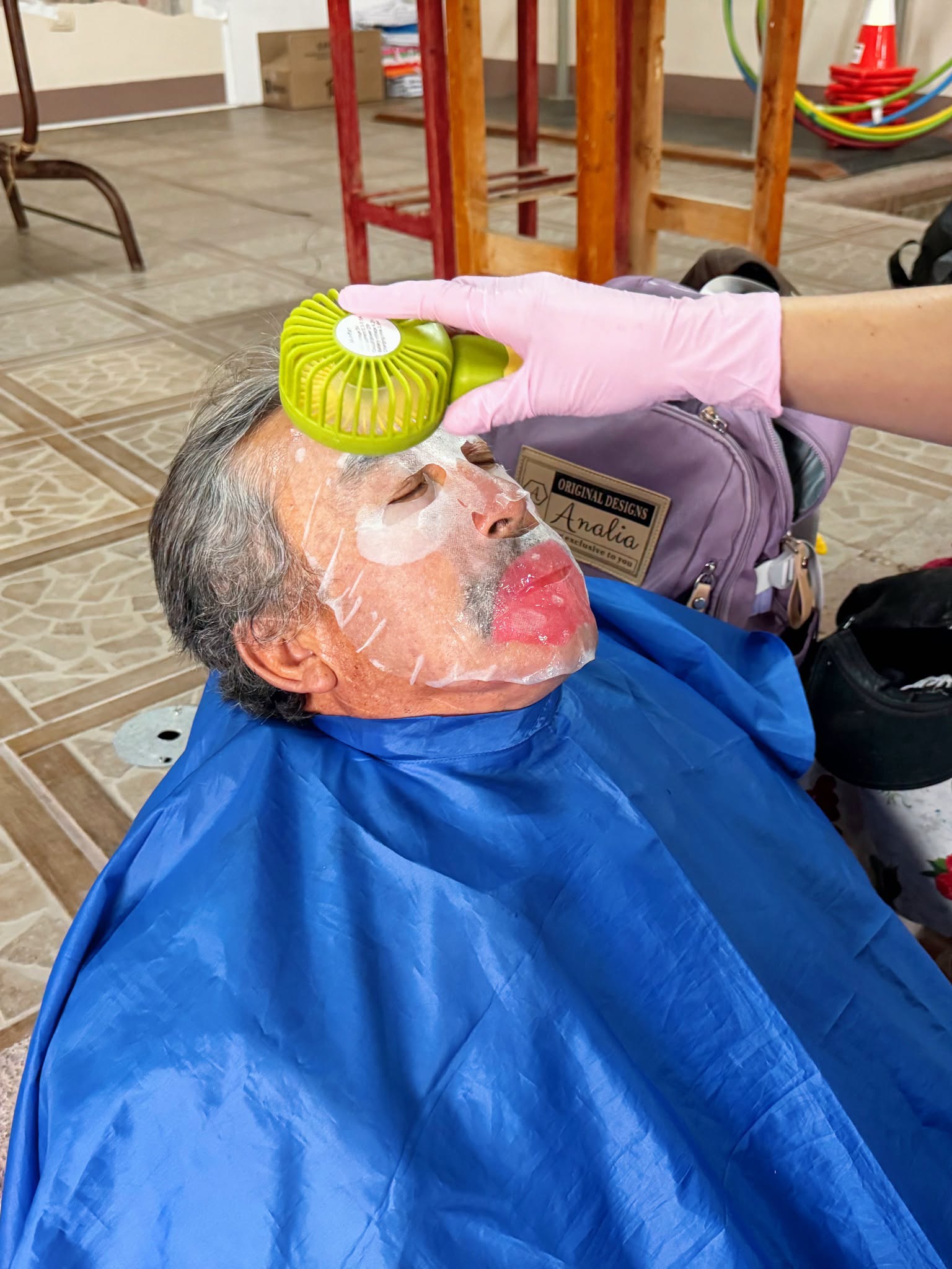 Adulto mayor recibiendo un tratamiento facial durante la jornada de autocuidado