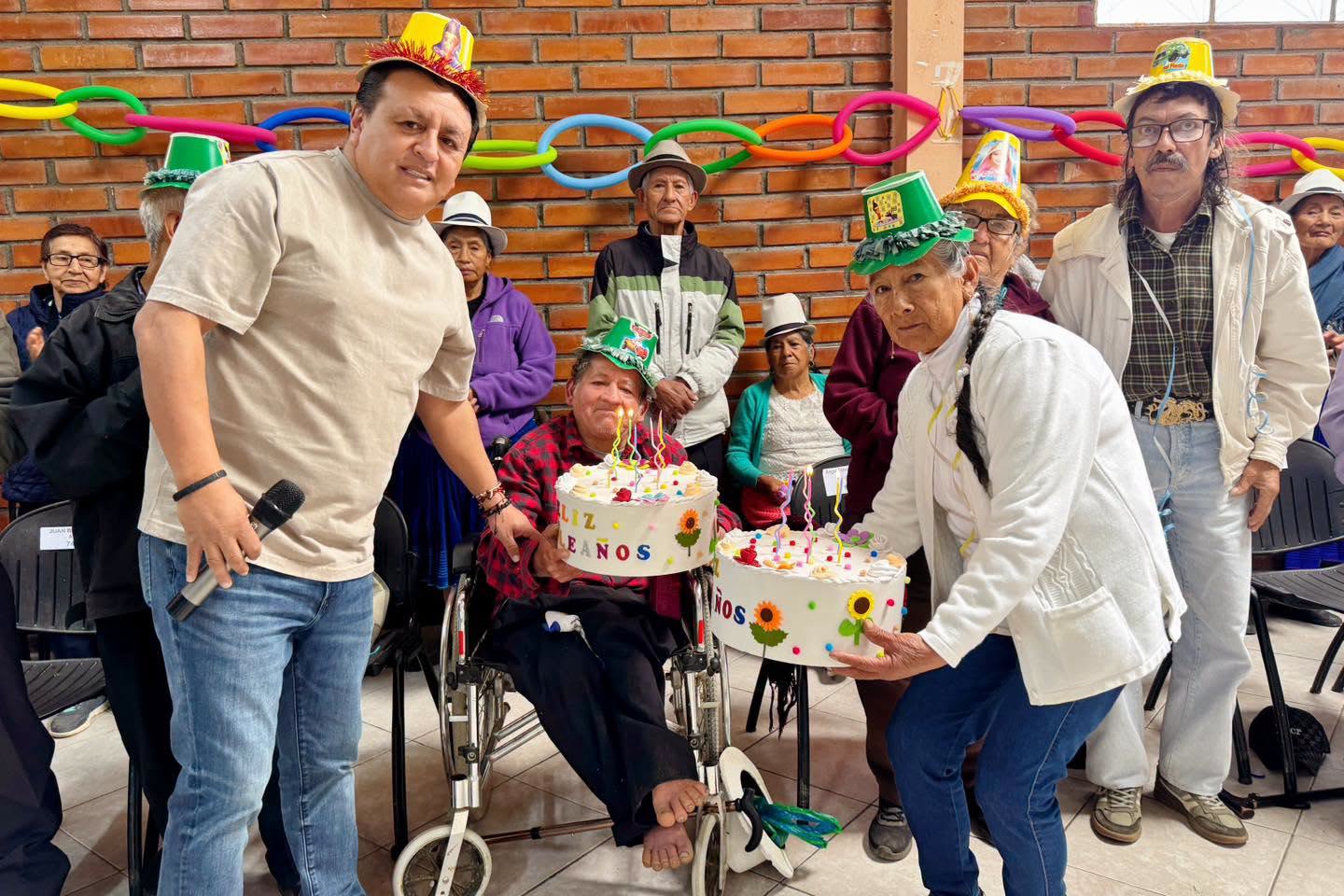 El alcalde junto a dos participantes y un pastel durante la celebración de cumpleaños de los grupos de atención prioritaria