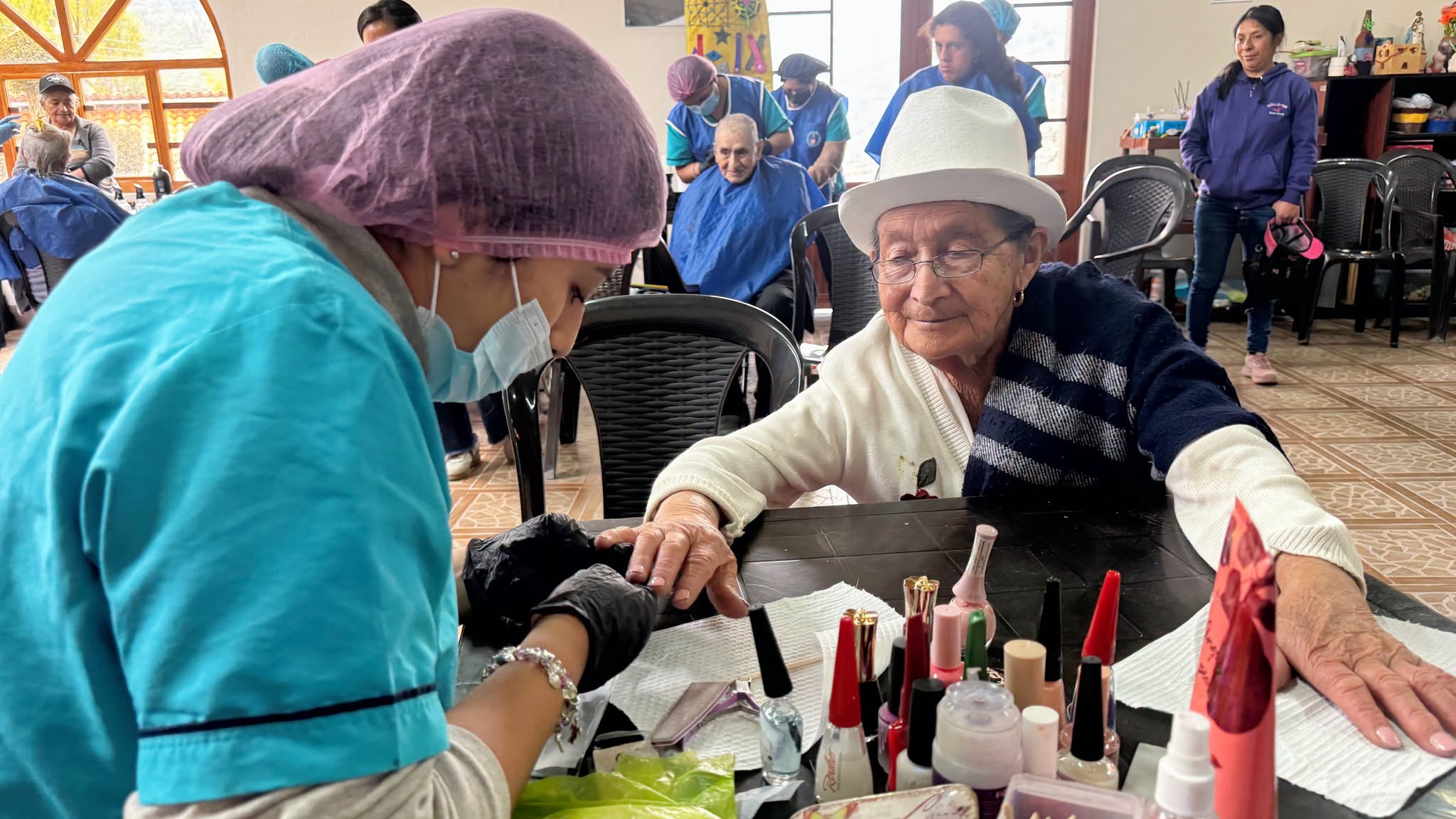 Adulta mayor recibiendo servicio de manicure durante la jornada de autocuidado